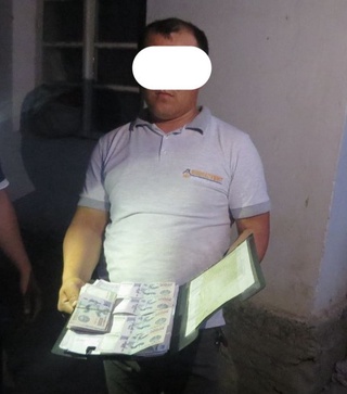 Jarima qoʻllamaslik evaziga 2,6 million soʻm olgan xodim ushlandi