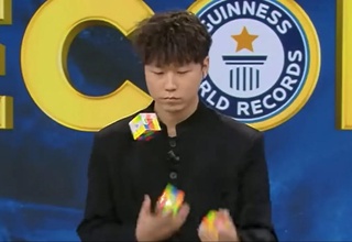Xitoylik erkak uchta Rubik kubigini jonglyorlik mahoratini ko'rsatgan holda uch daqiqa ichida yig'di